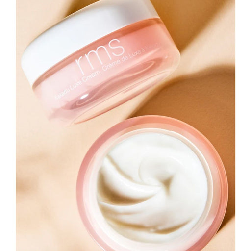 RMS Beauty Kakadu Luxe Cream open and one jar tilted with tanish background