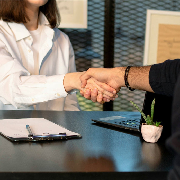 A woman shaking hands with her boss in a professional office setting