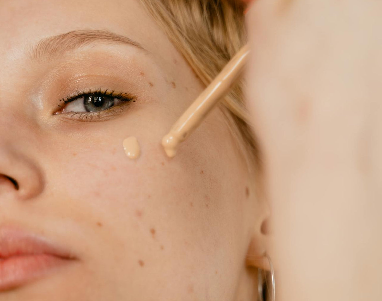 Women Applying Foundation On Her Face