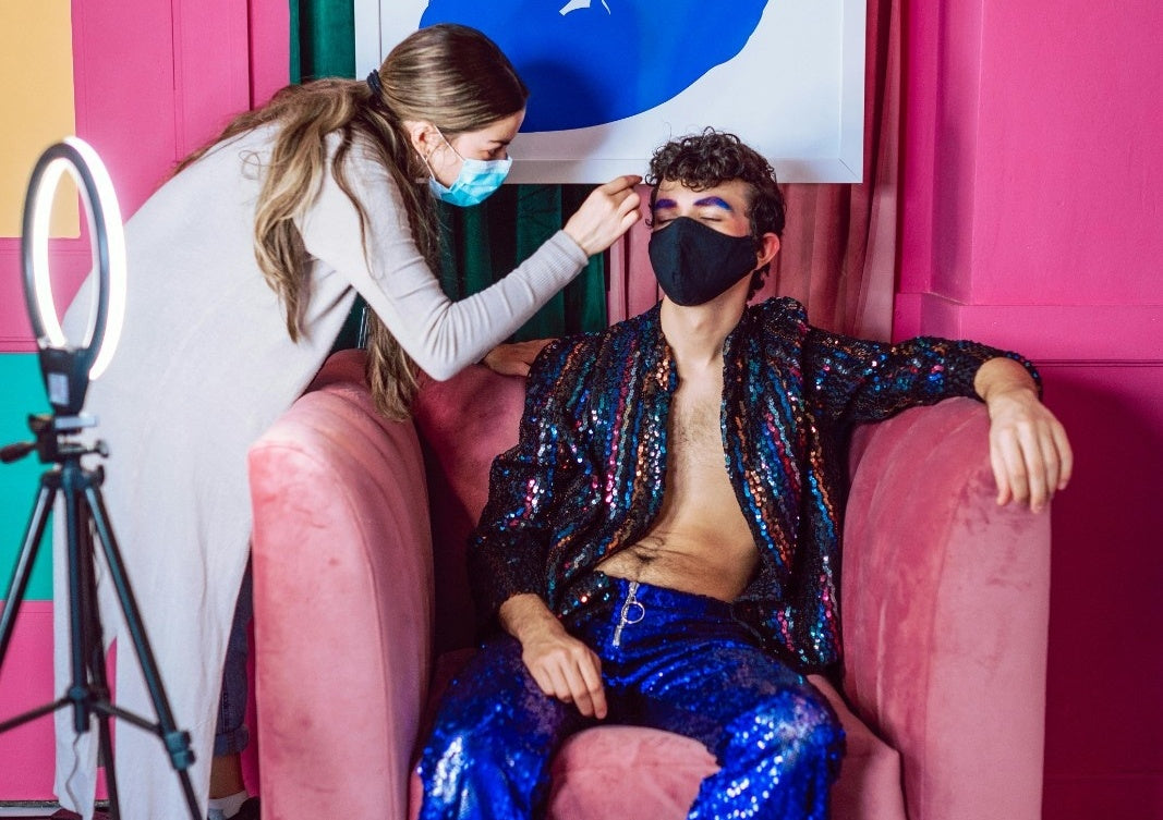 Makeup artist touching up talent’s makeup on-set