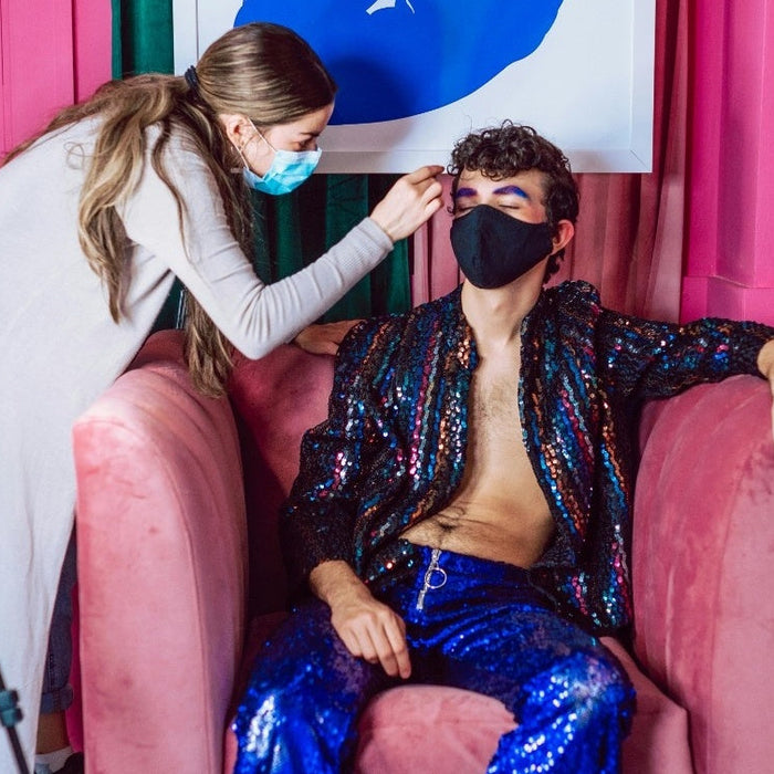 Makeup artist touching up talent’s makeup on-set