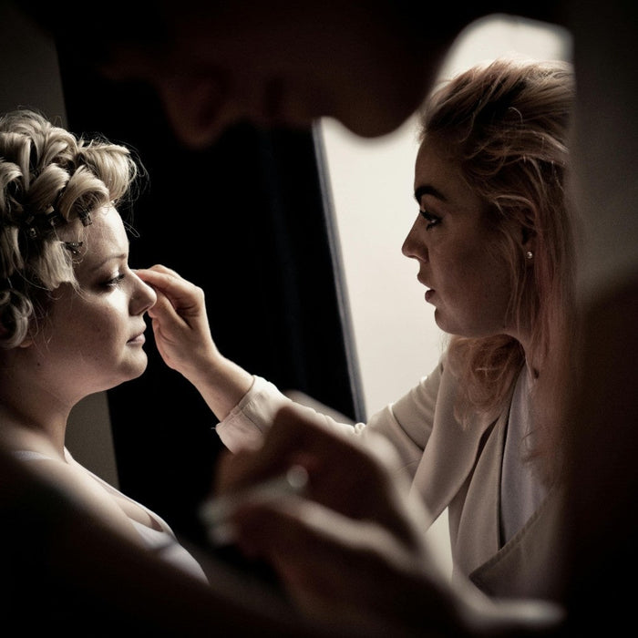 Makeup artist applying eye products to the client