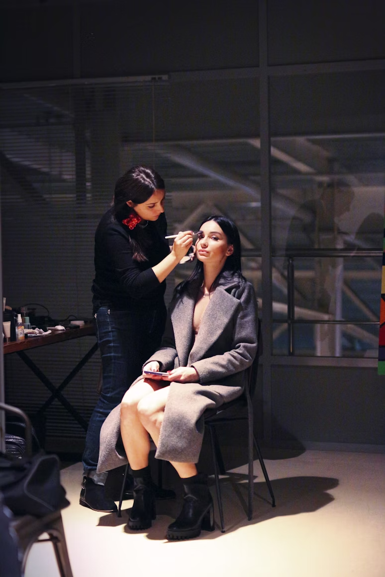 A makeup artist applying makeup to an actress