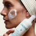 Caudalie Vinoclean Instant Foaming Cleanser, product on model cheek