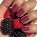 Glamnetic Press-On Nails Berry Maroon styled on model hand, holding blackberries and raspberries