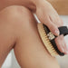 Kitsch Exfoliating Body Dry Brush in use on model leg
