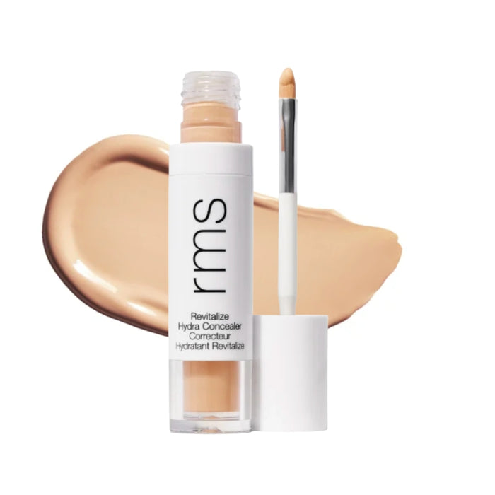 RMS Revitalize Hydra Concealer with swatch behind product against white background.