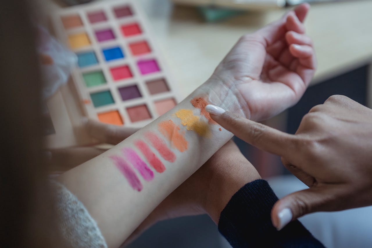 An arm with color swatches from an eyeshadow palette