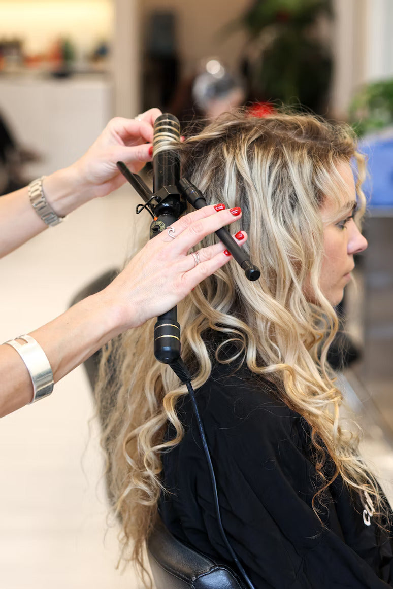 a hair stylist curling hair