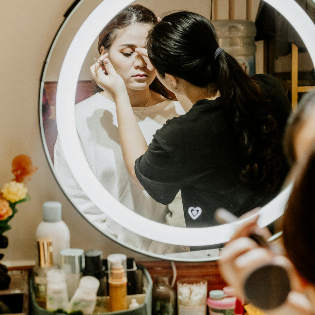 Reflection of a makeup artist in a beauty studio with a client