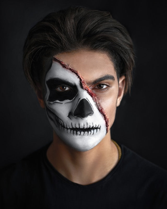 Man wearing Halloween skull makeup on half his face
