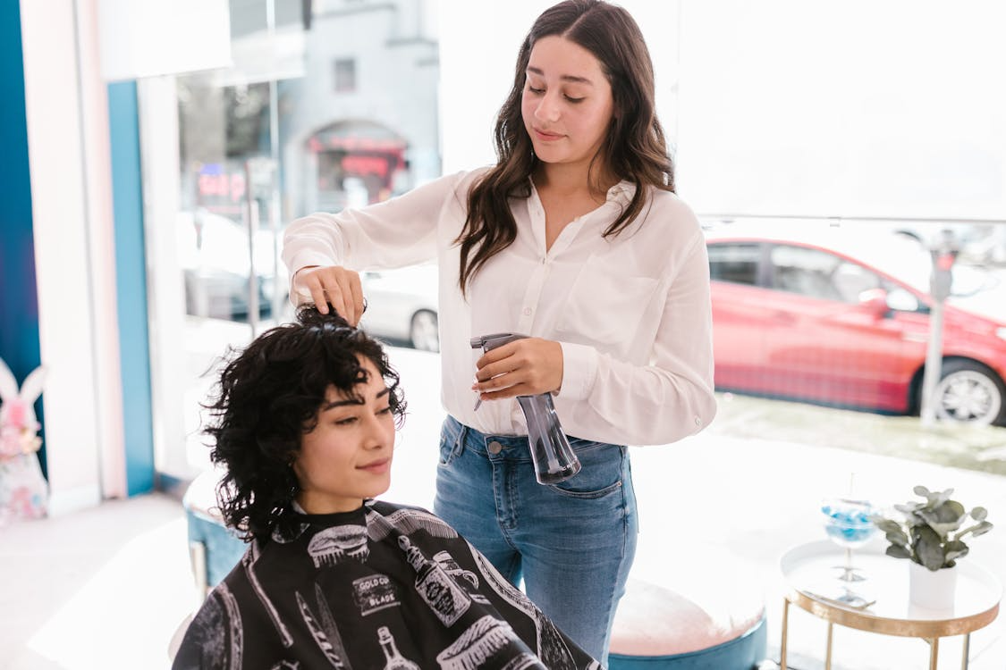 Woman getting her curly hair styled in a salon