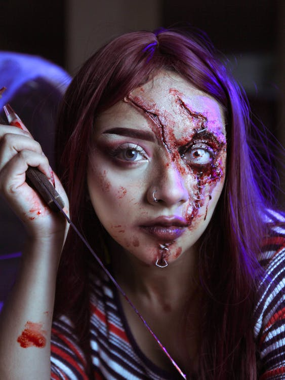 Woman with purple hair and bloody scars on her face